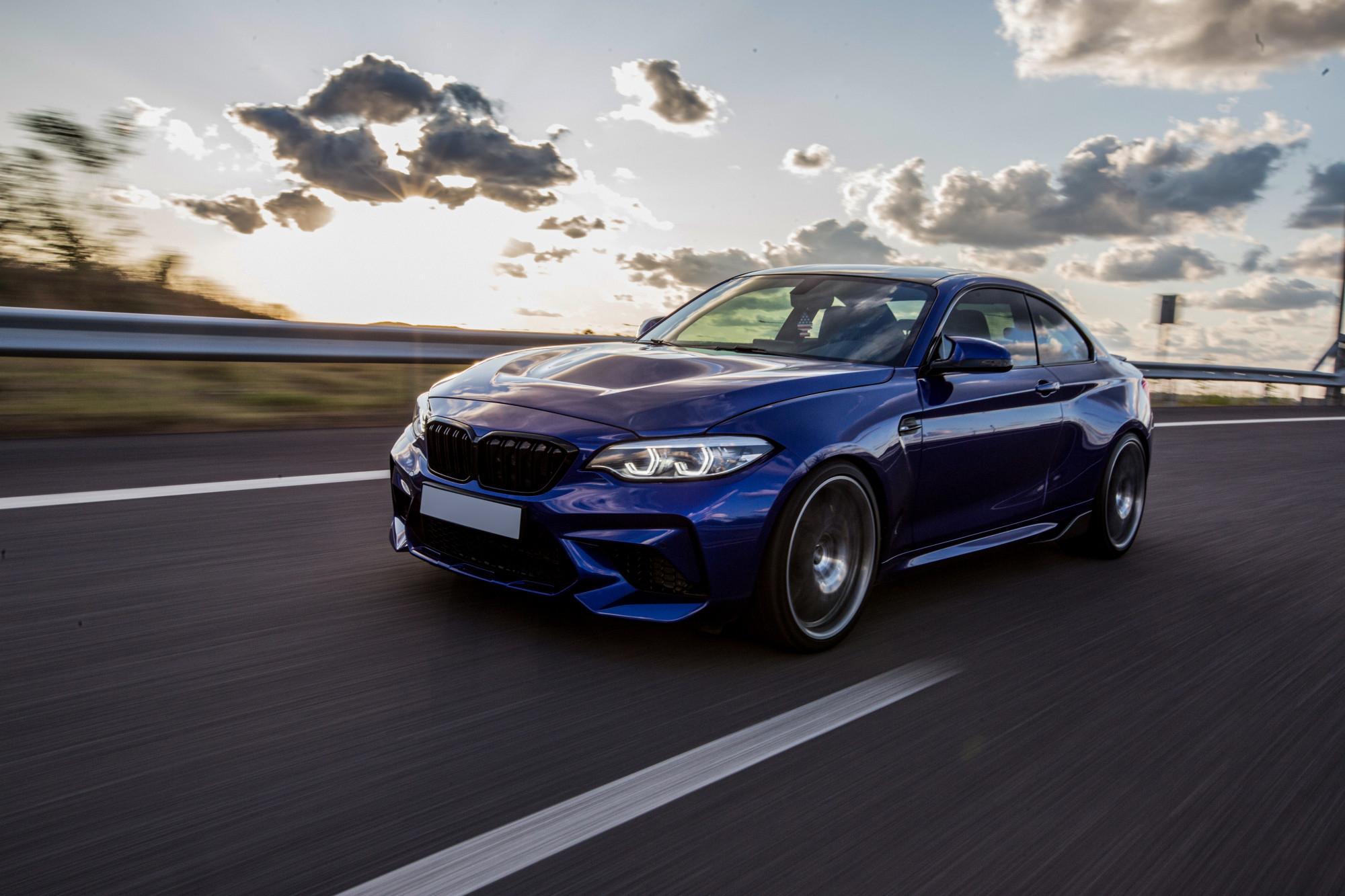 blue-sedan-car-driving-road-cloudy-weather (1)