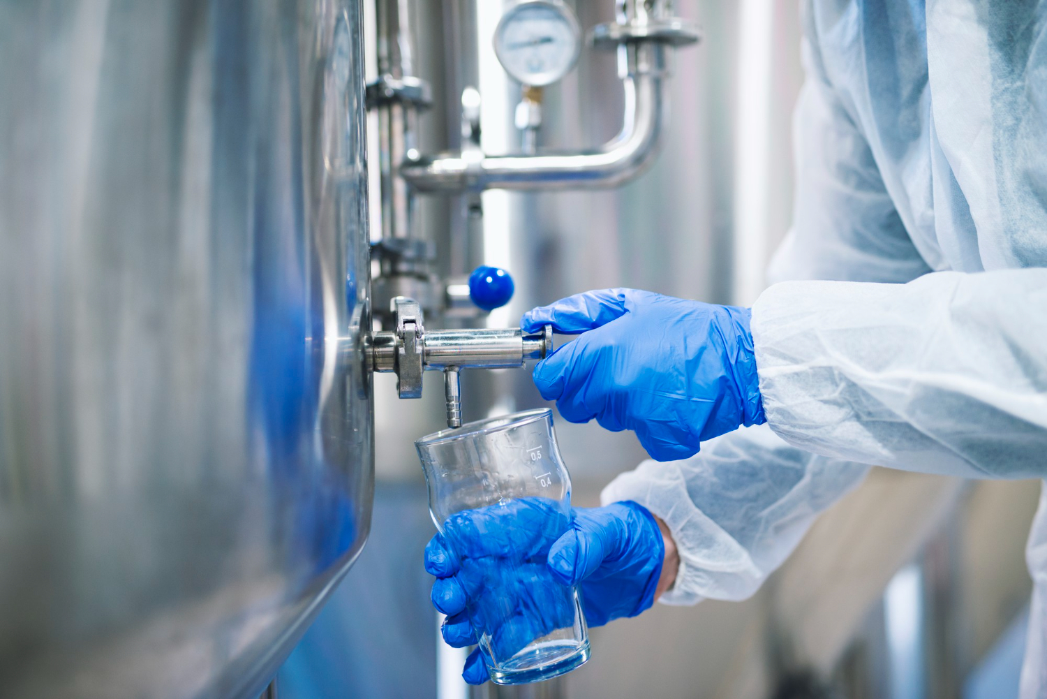 close-up-view-hands-protective-gloves-opening-tap-valve-filling-glass-with-samples-from-industrial-machine-reservoir-1