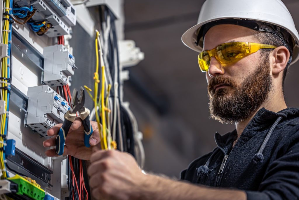 male-electrician-works-switchboard-with-electrical-connecting-cable-1024x683